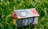 Picture of house made out of Australian currency on green grass